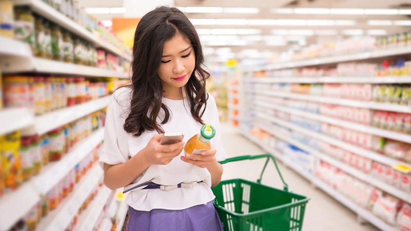 Woman shopper compares price on product on phone